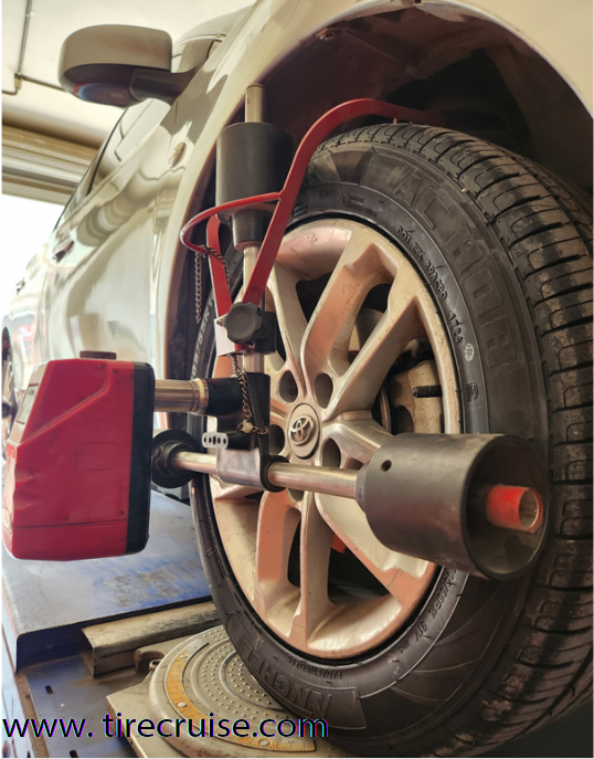 Mechanic performing digital tire alignment.